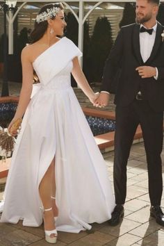 a man and woman in formal wear holding hands