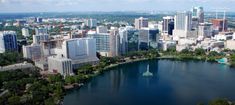 an aerial view of a city and its surrounding lake in the foreground, with tall buildings on both sides