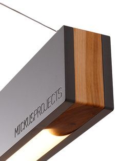 a close up of a light fixture with wood and metal on the bottom, which reads mick's projects