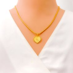 This 22k gold pendant, weighing 2.1 grams, features a heart-shaped design accented with delicate leaf embellishments that elegantly frame the word "Allah." The yellow gold finish enhances its radiant and sophisticated appearance, making it perfect for any occasion. Measuring 0.9 inches in length, this pendant symbolizes faith and devotion. Please note that the chain is not included. Ideal for those who appreciate meaningful and stylish jewelry, this pendant adds a touch of spiritual elegance to any collection. Its exquisite craftsmanship and intricate design make it a standout piece, perfect for enhancing your personal style. PRODUCT DETAILS Gold Purity(karat): 22k Gold Weight(grams): 2.1 Item Finish: Yellow Gold Pendant Length: 0.9" Chain: Not Included Traditional Gold Heart Pendant Necklace, Traditional Gold Jewelry With Heart Charm, Traditional Gold Heart Necklace, Bridal Jewelry Necklace, Precious Stones Rings, Diamond Pendant Sets, Fancy Necklace, Fancy Rings, Modern Bracelets