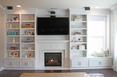 a living room filled with furniture and a flat screen tv mounted on the wall above a fire place