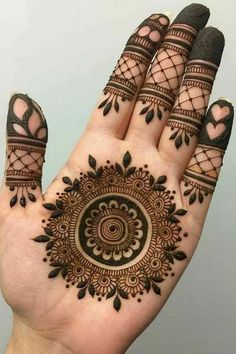 a hand with henna tattoos on it, and the design is intricately designed