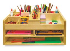 a wooden desk with lots of pens, pencils and markers on top of it