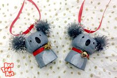 two stuffed koalas are hanging from red ribbon