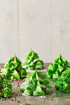 green christmas tree shaped cookies sitting on top of a table