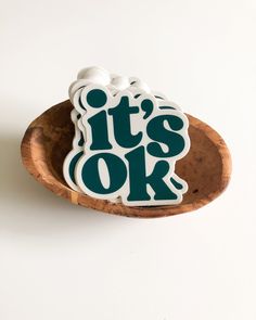 it's ok sticker sitting on top of a wooden spoon in a bowl