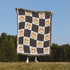 a person standing in front of a black and white blanket with smiley faces on it