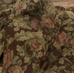 a close up view of a flowered fabric on a wooden table top with wood flooring