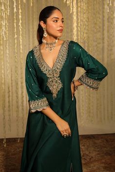 Emerald green long kaftan with placed thread embroidered paisley motifs embellished by sequins. Comes with matching doghri salwar.
Components: 2
Pattern: Embroidered
Type Of Work: Thread, Sequin
Neckline: V-neck
Sleeve Type: Three quarter
Fabric: Silk Dupion
Color: Emerald Green
Other Details: 
Flared silhouette
Occasion: Sangeet,Mehendi and Haldi - Aza Fashions Traditional V-neck Semi-stitched Salwar Kameez, Semi-stitched V-neck Dress For Festive Occasions, Semi-stitched V-neck Festive Dress, Elegant V-neck Kaftan For Festive Occasions, Designer V-neck Dresses With Zari Work, Green V-neck Sets For Eid, Festive V-neck Salwar Kameez With Zari Work, Designer Dabka Work V-neck Dress, Eid V-neck Kurta With Intricate Embroidery