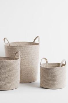 three round baskets with handles and handles on the sides, all in natural linens