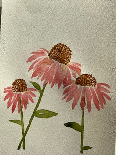 three pink flowers painted on white paper with green leaves