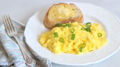 scrambled eggs with green onions on a white plate