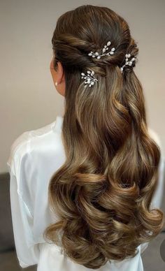 the back of a woman's head with long hair and flowers in her hair