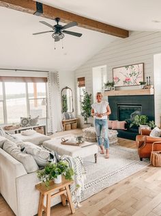 a woman walking through a living room filled with furniture