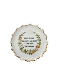 a white plate with flowers on it that says don't certiize your wife's assignment look who she married