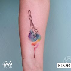 a tattoo on the arm of a woman with a whisk and colored ink