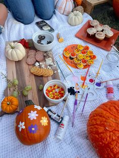 the table is set up with pumpkins, cookies and candy