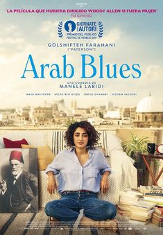 a woman sitting on top of a couch in front of a poster for the movie arab blues