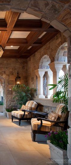 an outdoor living area with couches and potted plants