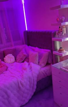 a bedroom with purple lighting and a bed in the corner that has pillows on it