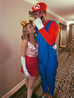 a man and woman dressed up as mario and princess peach are posing for the camera