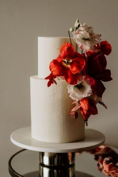 a white cake with red and white flowers on top