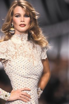 a woman is walking down the runway in a white dress