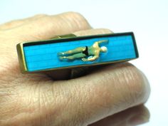 a person wearing a ring with a swimming man on it