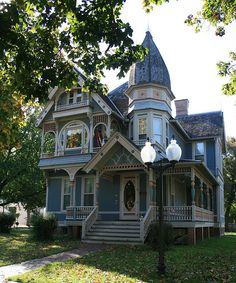 an old victorian style house with a turret on the top and second story is painted blue