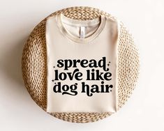 a t - shirt that says spread, love like dog hair on top of a wicker basket