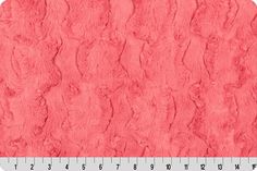 an image of a pink fur textured material with a ruler in the foreground