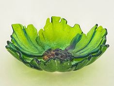 a green glass bowl sitting on top of a table