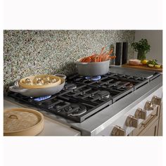 a stove top oven sitting inside of a kitchen next to a bowl filled with food