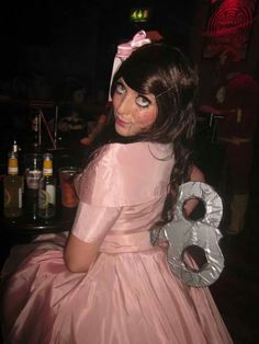 a woman in a pink dress holding a silver object