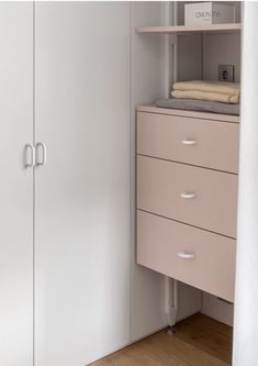 a white closet with pink drawers and shelves