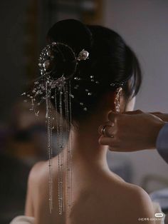 a woman is getting her hair done with beads