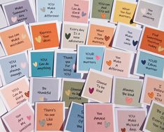 lots of cards with words and hearts on them are arranged in the shape of squares