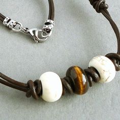 This is a tribal-inspired mens choker necklace that I carefully handcrafted with natural Tiger Eye and White Magnesite gemstone large hole beads on a genuine leather chocolate brown doubled 2mm cord, which I hand-knotted and braided with a special technique. The leather ends are finished off with pewter connectors in antiqued fine silver plating and a stainless steel oval clasp. Great for everyday casuals. The pictures represent a similar item you will receive in quality and shades.  Length O... Leather Round Beads Jewelry For Gift, Artisan Brown Jewelry With Waxed Cord, White Leather Bohemian Jewelry, White Bohemian Leather Jewelry, Bohemian White Leather Jewelry, Mens Choker, Mens Choker Necklace, Men Choker, Mens Leather Necklace