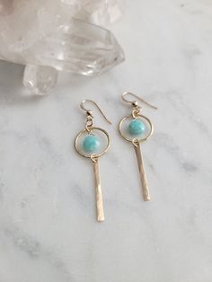 Nova Earrings featuring the Amazonite stone. These gems are such a pretty color! They are light and can be worn with a t-shirt and jeans or with a summer dress. The materials are your choice of 14k Gold Filled or Sterling Silver. Each piece is hammered for texture and shape. The length of the earrings are about 2 in. These are handmade and may vary slightly as well as the stones as they are natural. Thank you! Amazonite Stone, Handmade Wire Jewelry, Trendy Earrings, Hand Crafted Jewelry, Handmade Wire, T Shirt And Jeans, Crafted Jewelry, Beads And Wire, Jewelry Lover