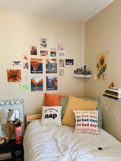 a bed with pillows and pictures on the wall above it, along with other items