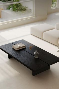 a modern living room with white couches and black coffee table