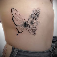 a woman's back with a butterfly and flowers tattoo on her left side ribcage