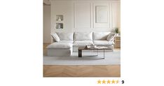 a white couch sitting in a living room on top of a hard wood floor next to a coffee table