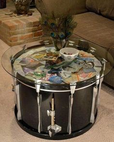 a glass table topped with magazines and a peacock figurine sitting on top of it