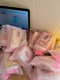 there are many bags of candy on the table next to a laptop computer and keyboard