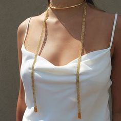 One of Camille's personal favorites! Not only is this style ultra versatile...could be worn 4 different ways!!! This scarf chain necklace looks spectacular worn alone or layered up! The Anuket versatile scarf chain necklace comes in a half hard collar with 10 strands of our signature faceted tubular design chain. Brass base 18K gold plated 4mm half hard round collar with caps: Size: 5 3/4" W x 3 3/4" H Tube design end caps. Size: 2.4mm x 19mm Delicate faceted tube chains Customize look up to fou Elegant Chain Lariat Choker, Party Lariat Chain Necklace With Double Chain, Elegant Lariat Chain Choker, Party Lariat Double Chain Necklace, Adjustable Snake Chain Elegant Choker, Adjustable Elegant Snake Chain Choker, Elegant Adjustable Snake Chain Choker, Elegant Snake Chain Choker, Elegant Gold Snake Chain Choker