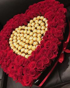 a heart - shaped box filled with roses and chocolates in the shape of a heart