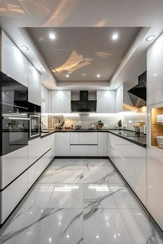 a kitchen with white cabinets and marble flooring