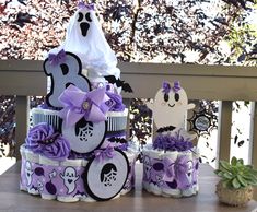 a purple and white diaper cake with ghost decorations