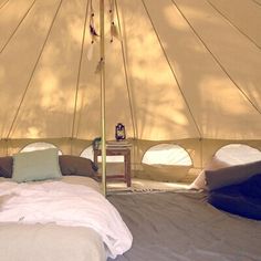 a bed in a tent with pillows and blankets